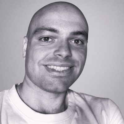 Black-and-white portrait of Ricard Santiago Raigada García, smiling, in a white T-shirt.
